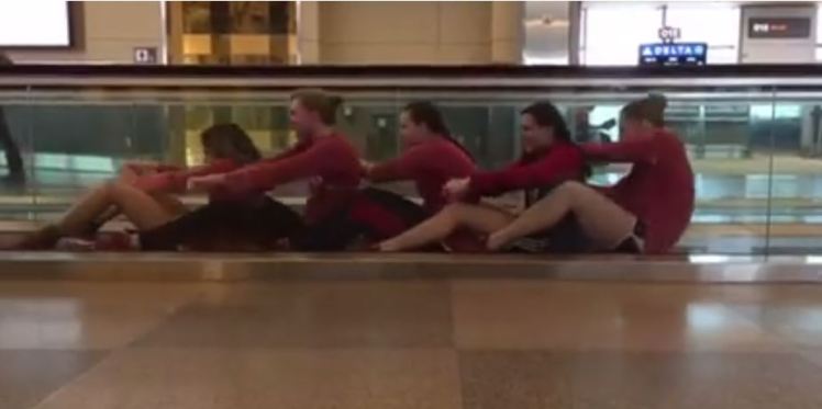 female-swim-team-entertain-themselves-in-airport
