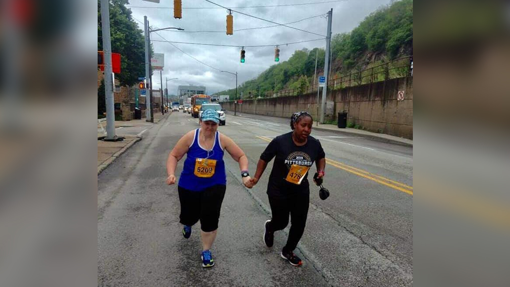 marathon runners hold hands