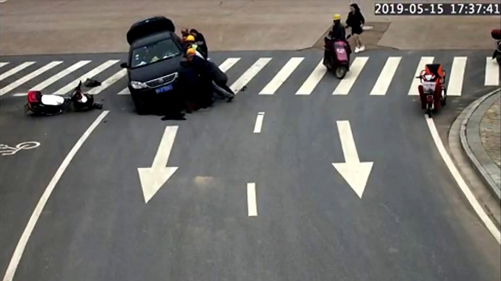 samaritans lift car to rescue motorcyclist