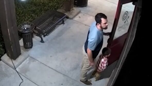 father and son stand guard at candy store